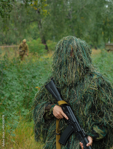 a Russian special forces soldier dressed in a camouflage suit holds a machine gun.  war.  copy space