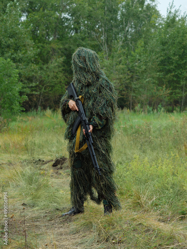 a Russian special forces soldier dressed in a camouflage suit holds a machine gun.  war.  copy space