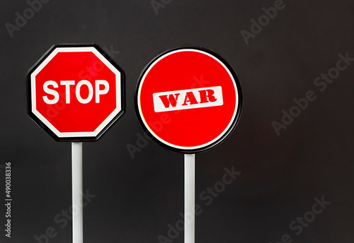 road signs on a black background with the inscription stop war