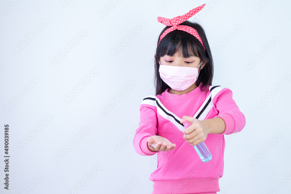 Asian child girl are strengthening to overcome the virus by wearing a mask and carrying alcohol bottles for washing hands, cleaning or spraying infected items. Covid-19 Asian child girl are strengthening to overcome the virus by wearing a mask and carrying alcohol bottles for washing hands, cleaning or spraying infected items. Covid-19