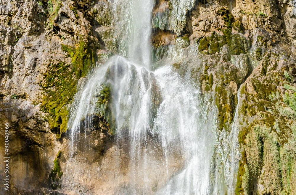 Water Flows Over a Vertical Steep Drop and Splash on the Mossy Rocks. Close Up View of the Great Waterfall in Plitvice Lakes National Park, Croatia. Water Flows Over a Vertical Steep Drop and Splash on the Mossy Rocks. Close Up View of the Great Waterfall in Plitvice Lakes National Park, Croatia.
