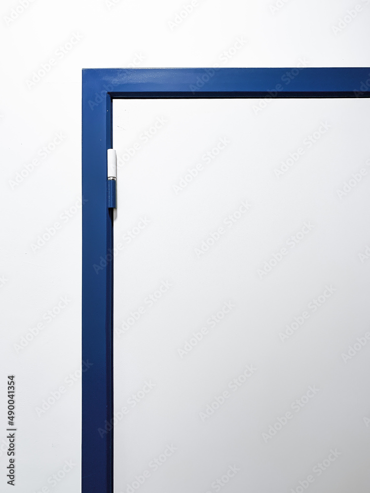 Part of a white metal door with a blue frame Part of a white metal door with a blue frame