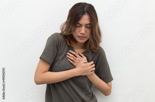 Young beautiful asian woman having heart attack isolated on white background 