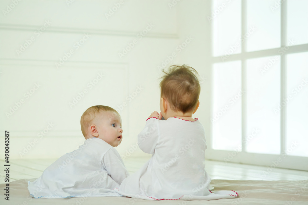 A two small newborn baby is in a bright room. The concept of childhood A two small newborn baby is in a bright room. The concept of childhood