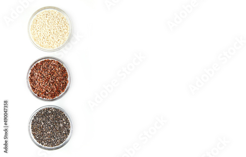 Chia, flax, sesame in glass bowls isolated on white background