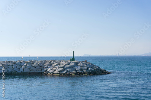Rock jetty and small lighthouse in the seaport of Premia de Mar