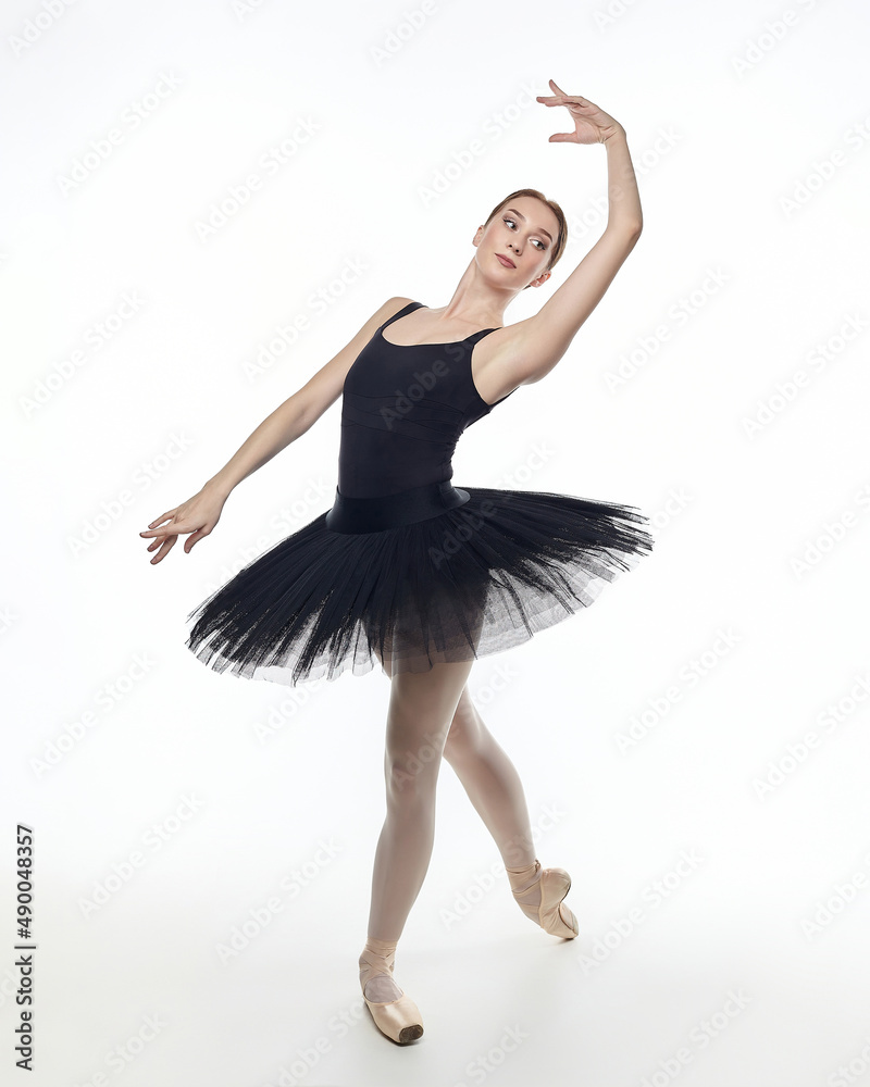 attractive ballerina stands on her fingertips. photo shoot in the studio on a white background