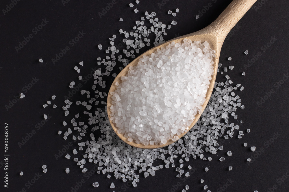 Wooden spoon with salt on a dark background Wooden spoon with salt on a dark background