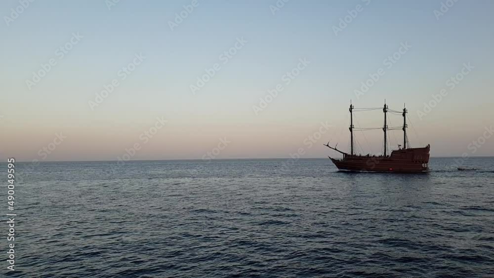 an ancient frigate sails on the sea at sunset an ancient frigate sails on the sea at sunset