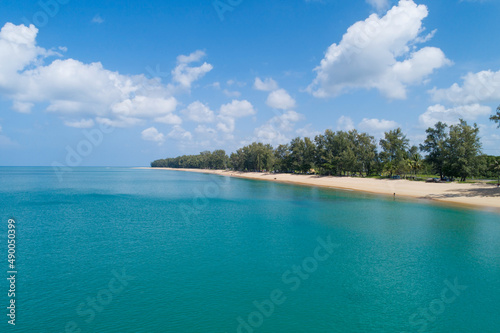 Aerial view Drone camera of Tropical sea with Row of pine trees near the beach in Thailand Beautiful sea and sky Travel and tour concept
