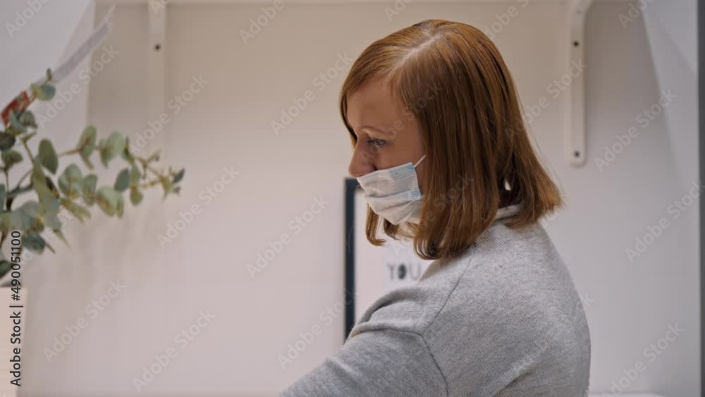Woman in medical face mask choosing new furniture for her house at store is New normal covid shopping closeup
