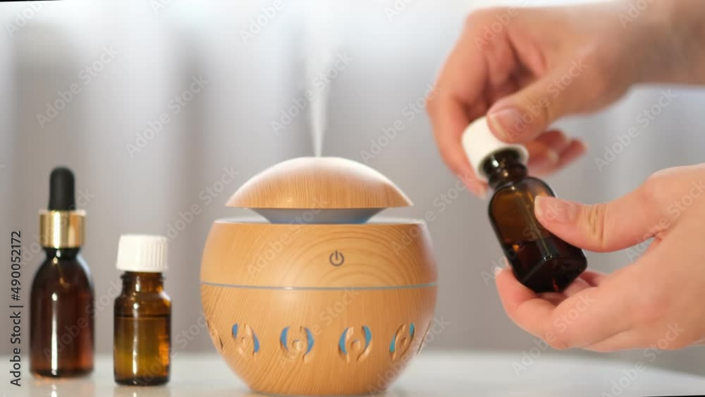 Modern aroma oil diffuser on the white table. Spa concept for body and health care. aroma of steam coming out of an electric diffuser. pleasant smell in the house. aromatherapy concept