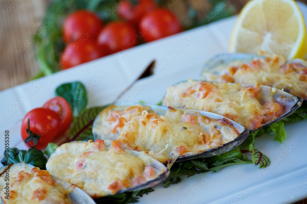 Mussels baked in sashes with parmesan. The concept of a menu for a restaurant or cafe.