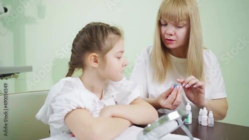 ophthalmologist explains to girl how to use night treatment contact lenses  photo