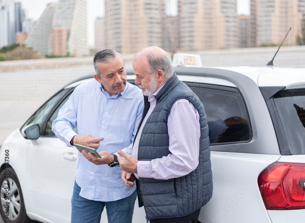 customer shows the elderly cab driver the address on the mobile where he wants to go-transport concept, cab, taxi and technology customer shows the elderly cab driver the address on the mobile where he wants to go-transport concept, cab, taxi and technology