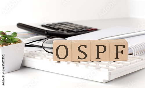 OSPF written on a wooden cube on keyboard with office tools photo