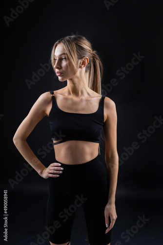 portrait of a beautiful caucasian female in sportswear on a black background 