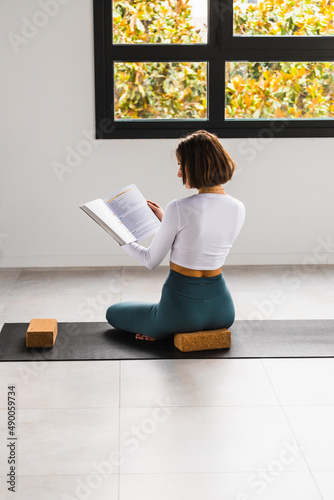 CHICA JOVEN LEYENDO LIBRO DE YOGA Y MEDITACION