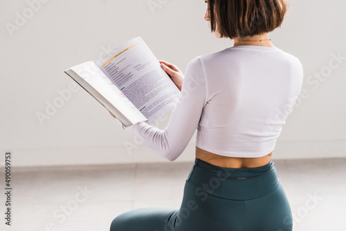 CHICA JOVEN LEYENDO LIBRO DE YOGA Y MEDITACION