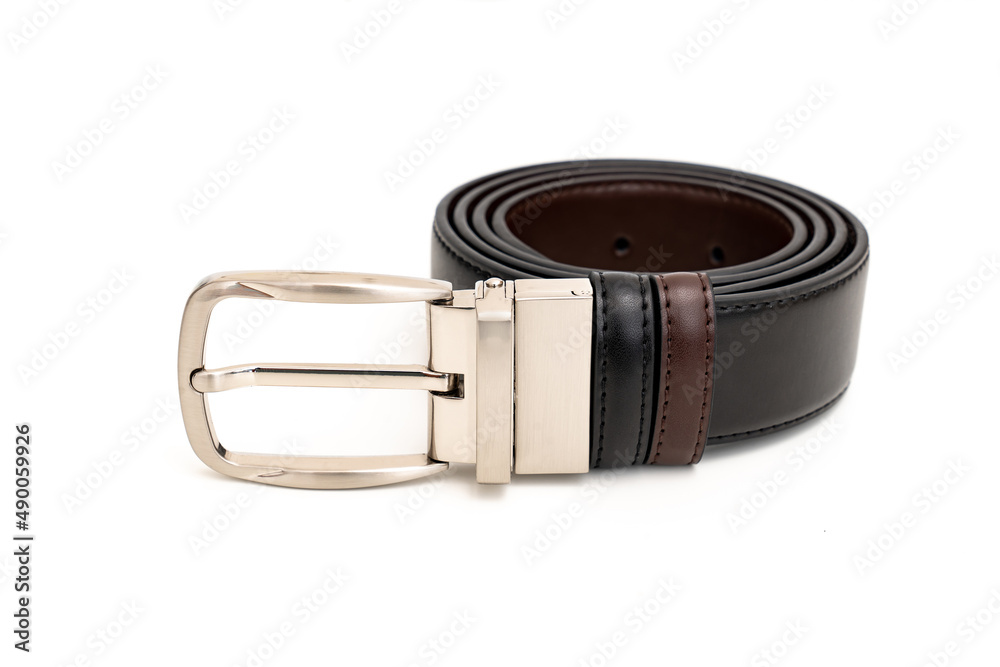 Double-sided black and brown leather belt with an unbuttoned buckle on a white background. Double-sided black and brown leather belt with an unbuttoned buckle on a white background.