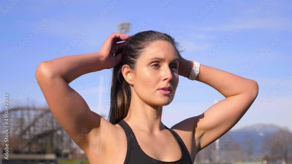 Attractive athletic woman tying up hair before run Medium shot Attractive athletic woman tying up hair before run Medium shot