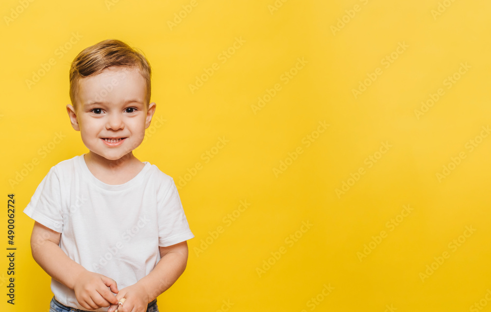 Portrait of a cute laughing little boy on a yellow background. Copy space. Portrait of a cute laughing little boy on a yellow background. Copy space.
