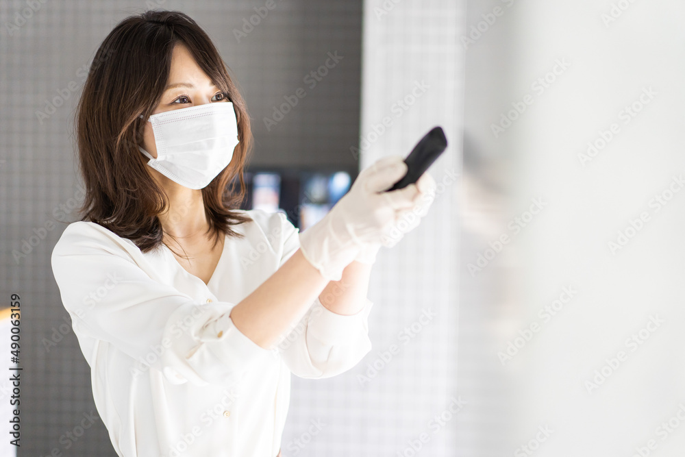 感染拡大防止のためにお客様の体温を計測するスタッフ