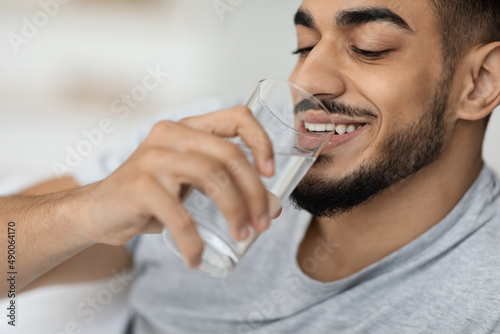 Portrait Of Handsome Young Arab Man Drinking Water From Glass