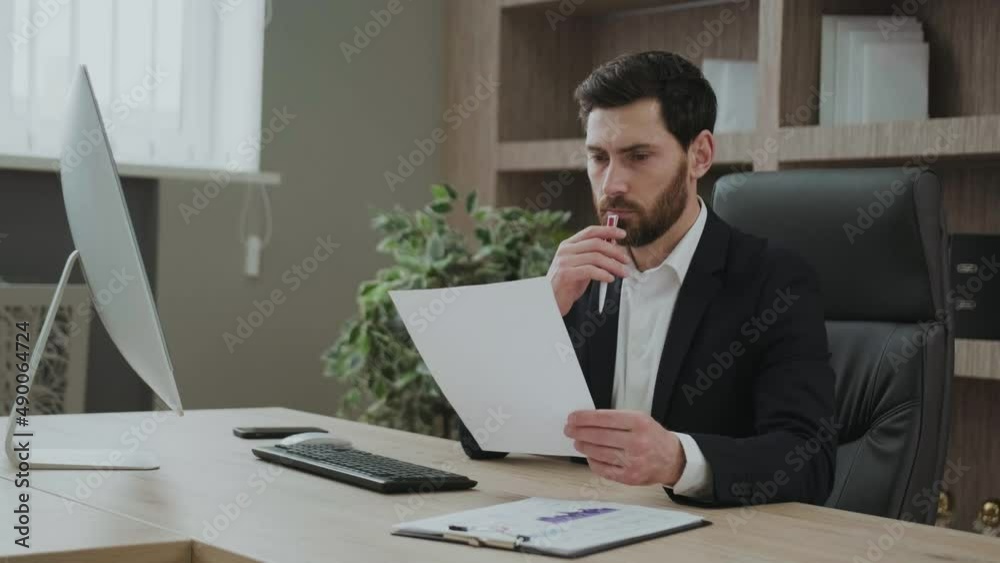 Financial analytics or entepreneur writing report, doing market research with documents in front of the computer screen Financial analytics or entepreneur writing report, doing market research with documents in front of the computer screen