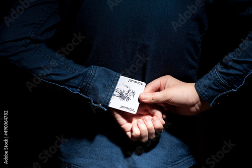 Lviv, Ukraine - 01.03.2022: human hands pulling a joker card from the sleeve