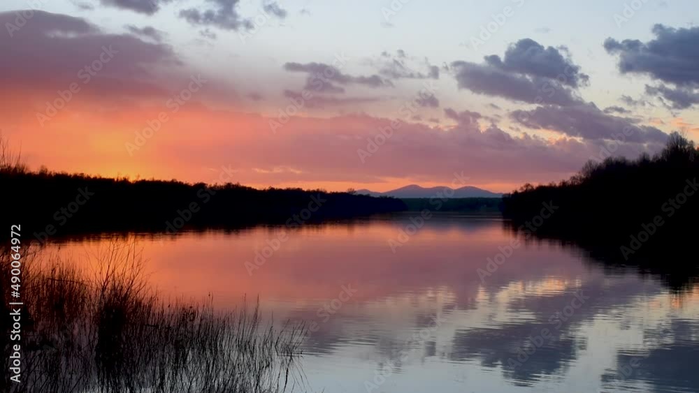 Landscape of river and mountain and orange glow in clouds at sunset Landscape of river and mountain and orange glow in clouds at sunset