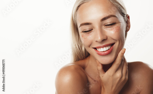 Portrait of smiling blond woman with white healthy smile, showing perfect teeth, head and shoudlers, smooth natural skin facial tone, standing over white background