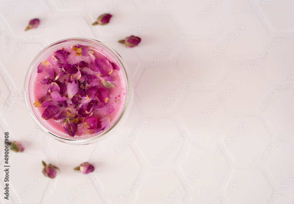 Pink rose milk with rose petals in a glass. Healthy drink moon milk ...