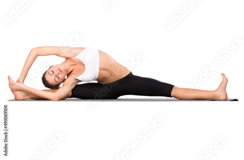 Fototapeta Naklejka Na Ścianę i Meble -  Stretching before her workout. An attractive young woman istretching against a white background.