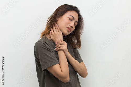 beautiful asian young woman with sore throat neck and shoulder pain, isolated on a white background