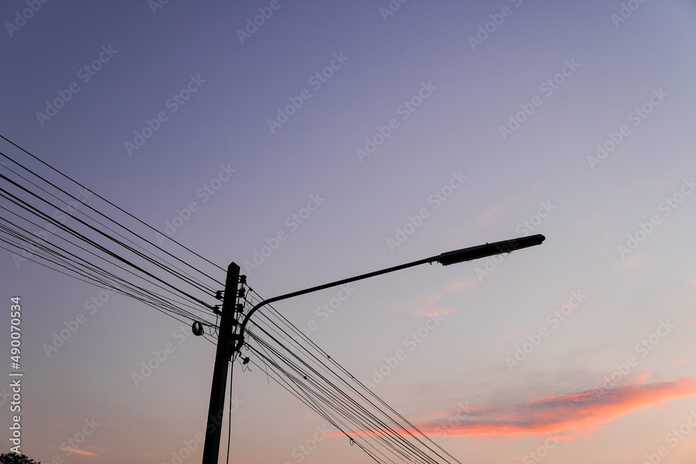 electric poles and wires in the pink evening sky