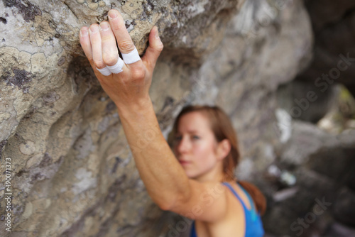 Strong fingers. A rock climber trying to get her grip.