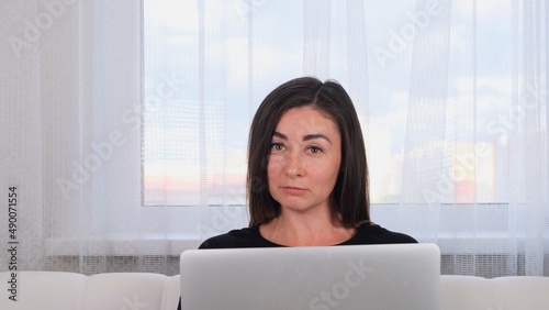 brunette girl blogger talking with friends on social networks on laptop using wireless internet. Positive young woman shopping online on the website