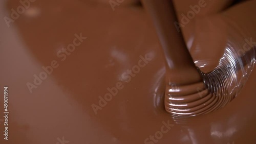 Close-up stirring chocolate, hot melted liquid chocolate.