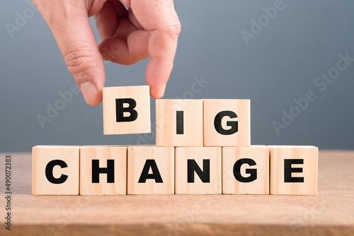 Closeup hand put a final alphabet cube into the word: Big Change, set by alphabet wood blocks, business, and career opportunity concept