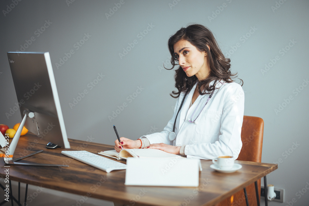 Shot of smiling female doctor working with her laptop in the consultation. Female doctor using a digital tablet at her desk in the clinic. Female doctor working on her tablet pc in her office. Shot of smiling female doctor working with her laptop in the consultation. Female doctor using a digital tablet at her desk in the clinic. Female doctor working on her tablet pc in her office.