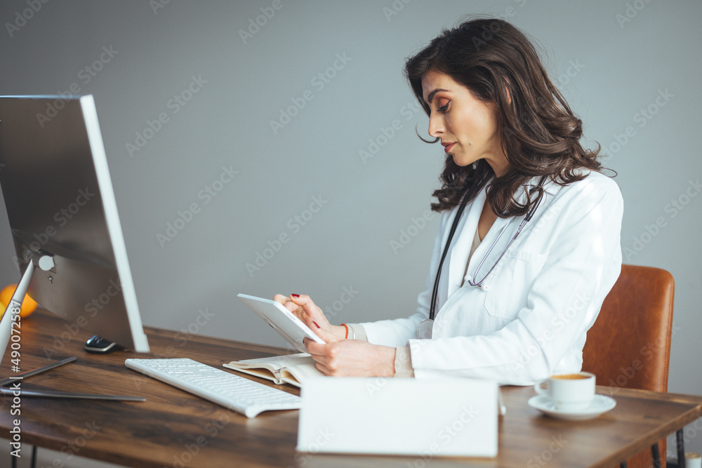 © Dragana Gordic - Portrait Of Smiling Female Doctor Wearing White Coat With Stethoscope In Hospital Office. Smiling doctor holding a tablet PC in a modern office. © Dragana Gordic - Portrait Of Smiling Female Doctor Wearing White Coat With Stethoscope In Hospital Office. Smiling doctor holding a tablet PC in a modern office.
