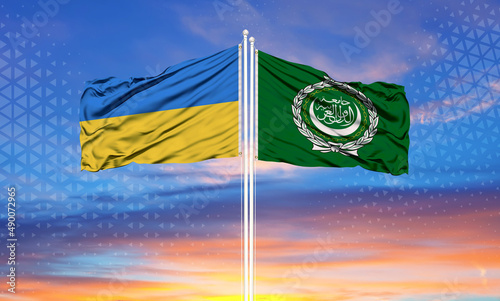 The flag of Ukraine and the Arab League on the flagpole and the blue sky photo