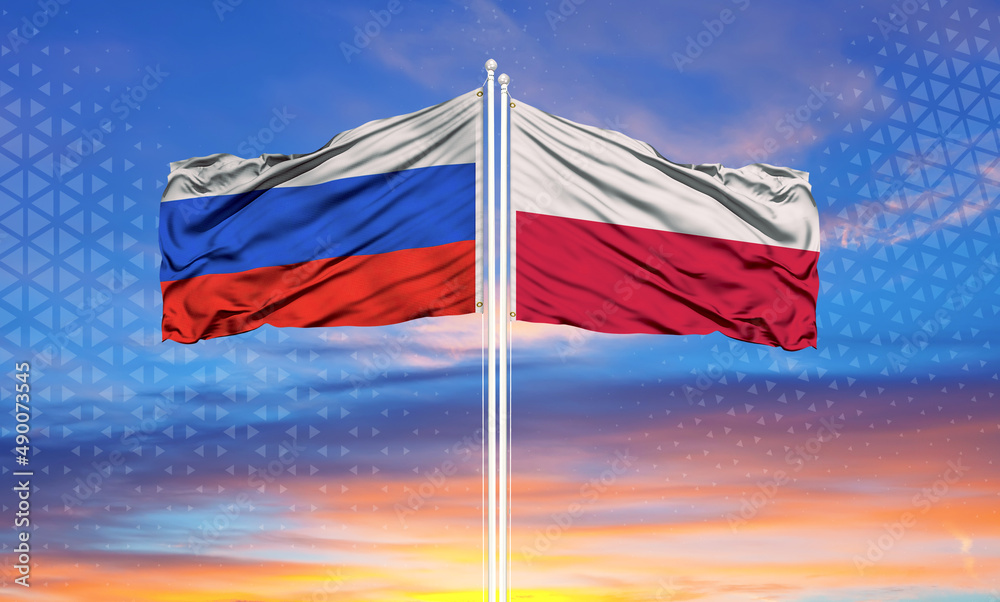 Russia and Poland two flags on flagpoles and blue cloudy sky..
