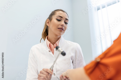 Neurological examination. The neurologist testing reflexes on a female patient using a hammer. Diagnostic  healthcare  medical service