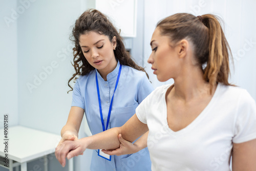 Doctor or Physiotherapist working examining treating injured arm of athlete patient, stretching and exercise, Doing the Rehabilitation therapy pain in clinic. photo