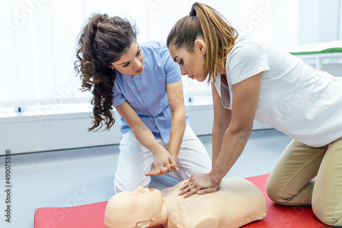 Demonstrating CPR (Cardiopulmonary resuscitation) training medical procedure on CPR doll in the class.Doctor and nurse students are learning how to rescue the patient.First aid for safe life concept. photo