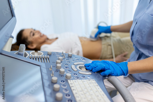 Canvas-taulu Side view portraits of gynecologist in white lab coat and sterile gloves using ultrasound scanner while examining female patient