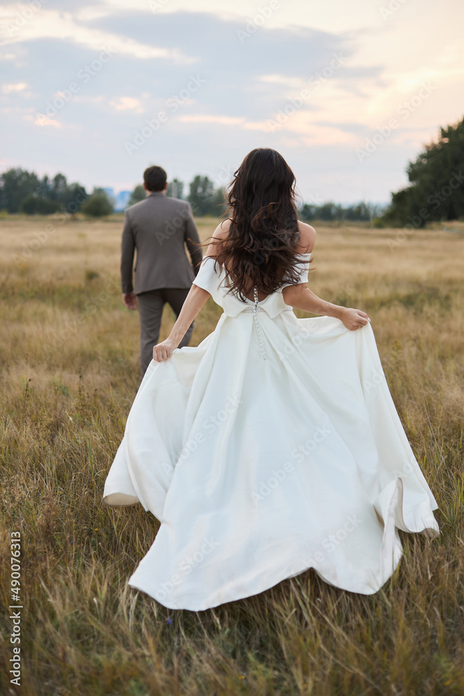 Young beautiful couple at sunset in the field