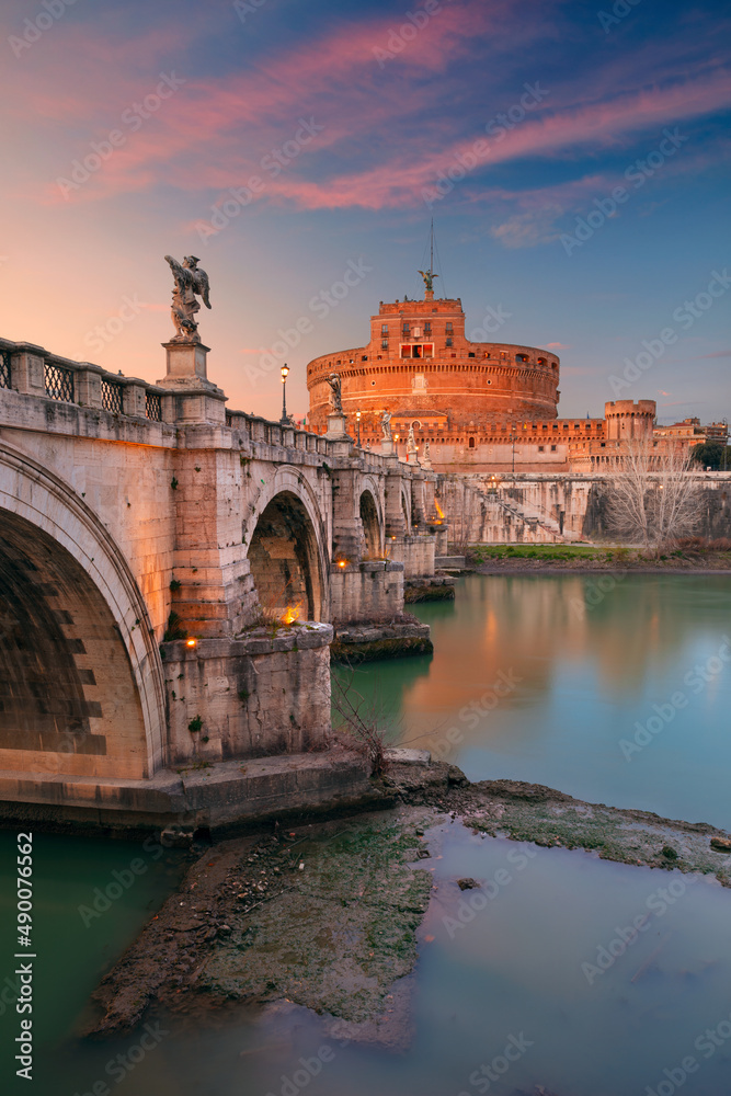 Rome, Italy. Image of the Castle of the Holy Angel (Castle of Sant Angelo) and Holy Angel Bridge (Ponte Sant Angelo) over the Tiber River in Rome at sunset.